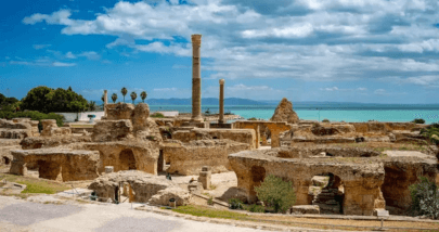 Panoramic view of a trip to the ruins of Carthage overlooking the Mediterranean Sea under a bright blue sky.