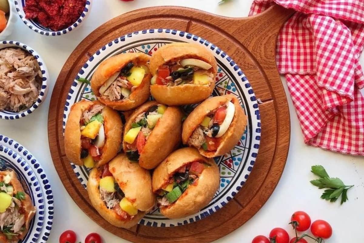 Tunisian fricassé sandwich filled with tuna potatoes eggs olives and harissa